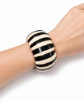 Bracelet manchette corne et os de zébu porté au poignet, noir et crème, artisanat malgache