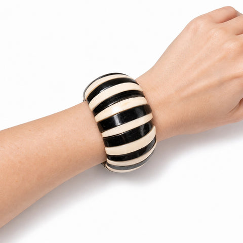 Bracelet manchette corne et os de zébu porté au poignet, noir et crème, artisanat malgache